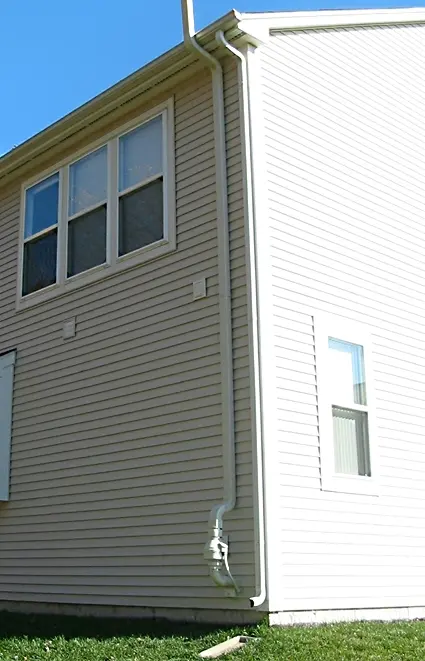 A radon mitigation pipe and fan mounted on a house wall. Shown on the homepage for Cedar Rapids, IA.