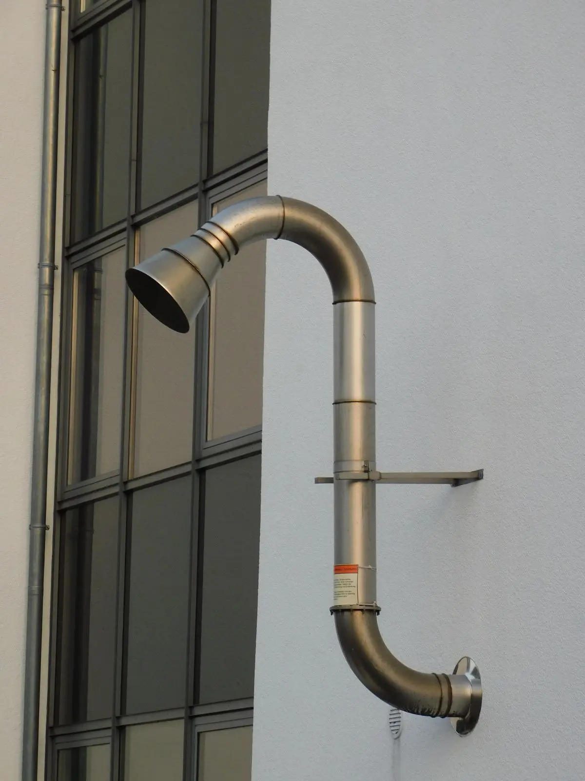 A metal exhaust vent pipe in a bright interior.